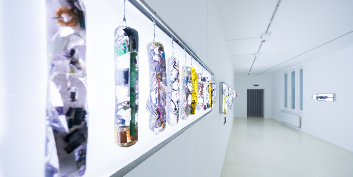 Gillian Brett, Smart Food: Better for you and the planet, 2019-2021, Detail Ausstellung Stadtgalerie Smart Food, Bockwürste aus Kunstharz vor einer LED Platte, gefüllt mit Elektroteilchen