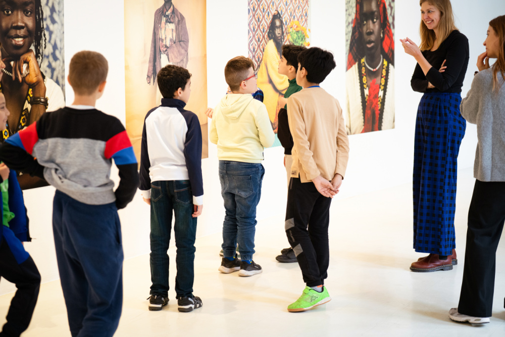 Kinder Eröffnung SUMM SUMM SUMM Stadtgalerie Eine Gruppe von Kindern schaut sich Fotos in einer Ausstellung an